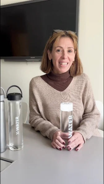 Personne tenant une bouteille réutilisable transparente à l’intérieur